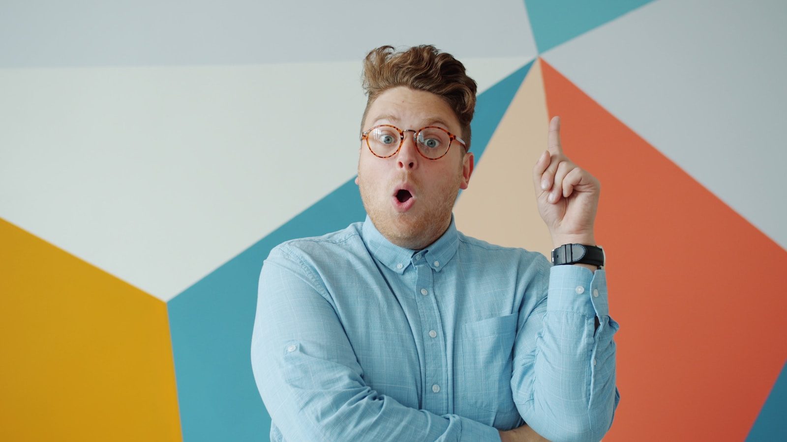 Man with glasses makes surprised expression with idea